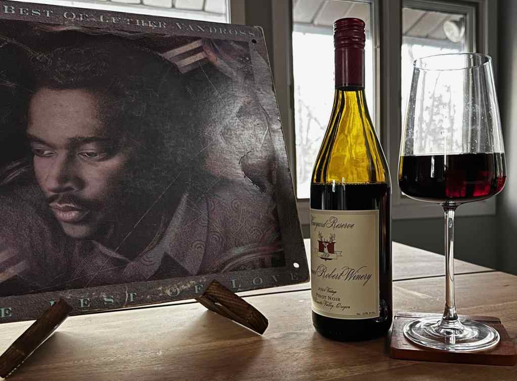 Álbum de Luther Vandross con una botella de vino tinto y una copa.