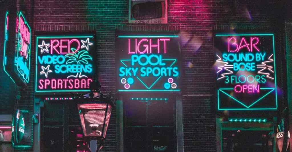 Dynamic neon-lit bar facade in Amsterdam's vibrant nightlife district.