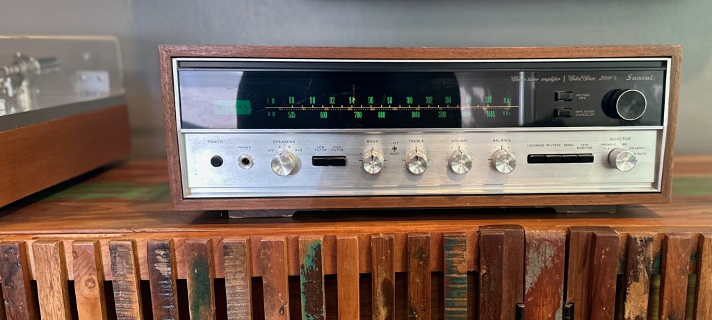 Sansui 2000X vintage stereo receiver in a home listening setup with turntable and wood cabinet