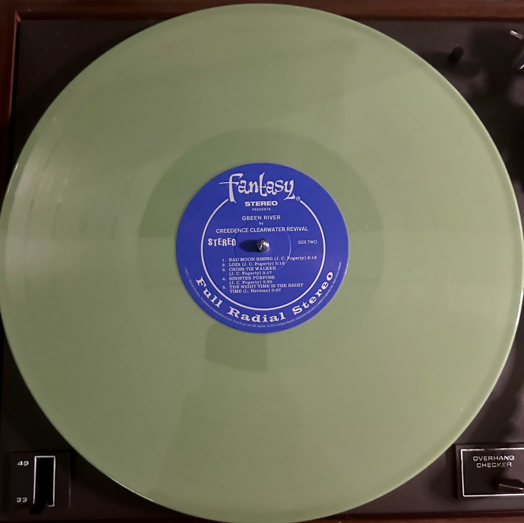 Army green vinyl reissue of Creedence Clearwater Revival’s Green River spinning on a turntable with Fantasy Records center label.