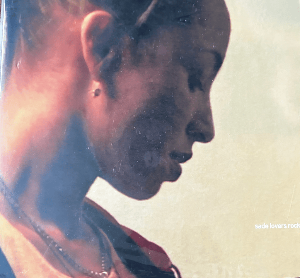 Sade’s Lovers Rock vinyl sleeve featuring a warm-toned profile portrait and the album title in the lower right corner.