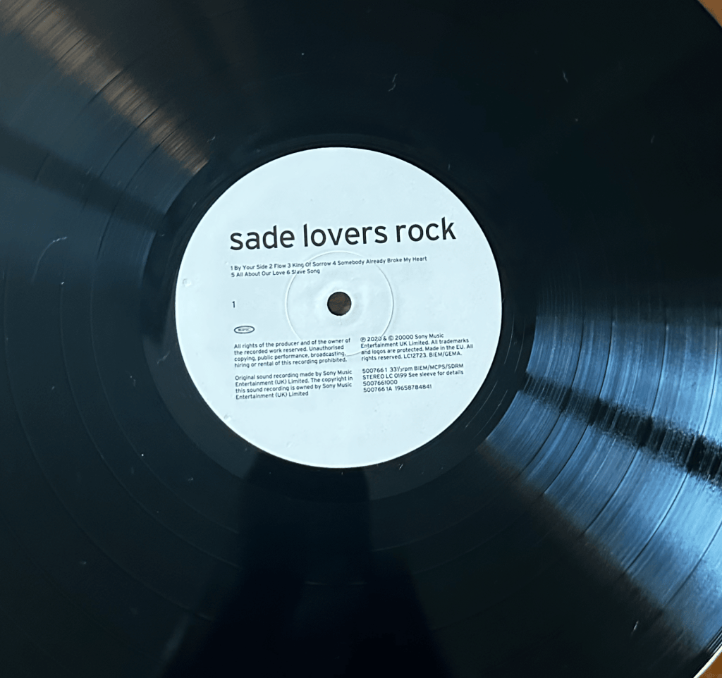 Sade Lovers Rock black vinyl record with a white Side One label showing the track listing and Epic logo.
